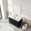 Bathroom vanity with white countertop, black cabinet, and gold fixtures.