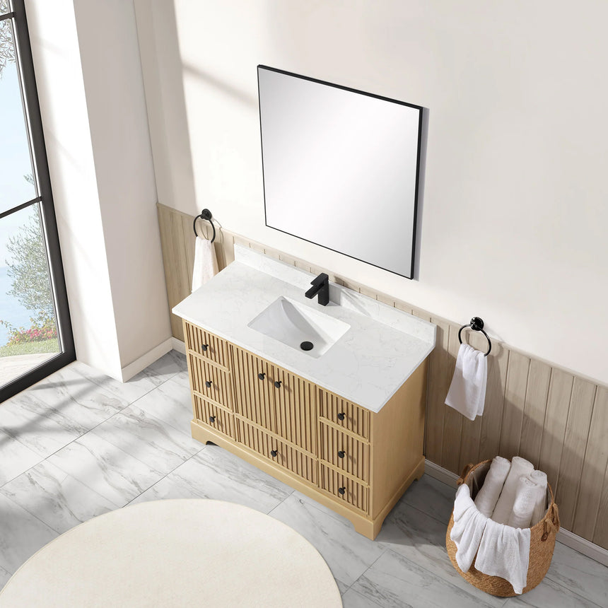Bathroom vanity with wooden cabinet and white countertop in a bathroom setting.