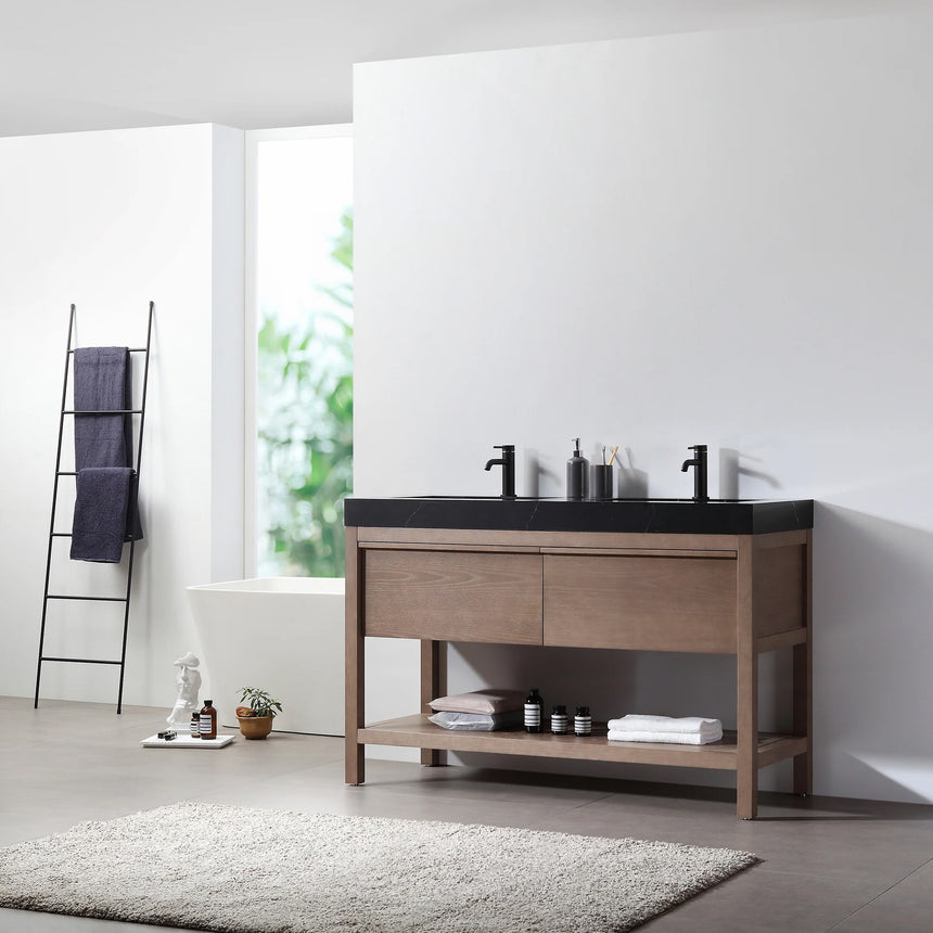 Bathroom vanity with black countertop and wooden cabinet in a bright room.