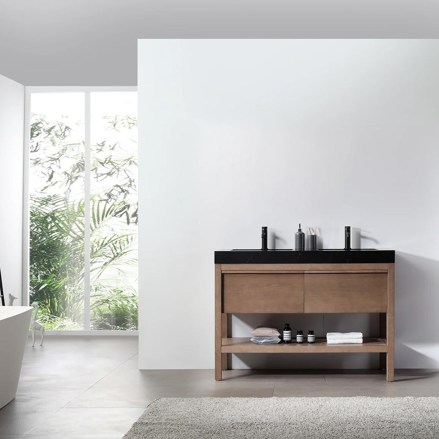 Bathroom vanity with black countertop and wooden cabinet in a bright room.