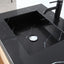 Black marble sink with a black faucet on a light gray countertop.