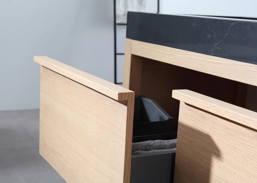 Bathroom vanity with black countertop and wooden cabinet in a bright room.