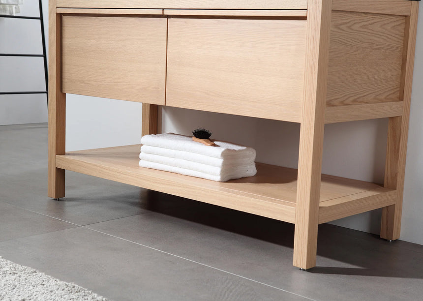 Bathroom vanity with black countertop and wooden cabinet in a bright room.