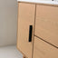 Wooden cabinet with a black handle on a neutral background