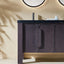 Bathroom vanity with dark wood finish and black countertop against a beige wall.