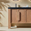 Wooden bathroom vanity with black countertop and sink against a beige wall.