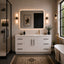 Modern bathroom with white vanity, mirror, and bathtub.