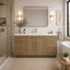 Modern bathroom with wooden vanity, mirror, and decorative elements.