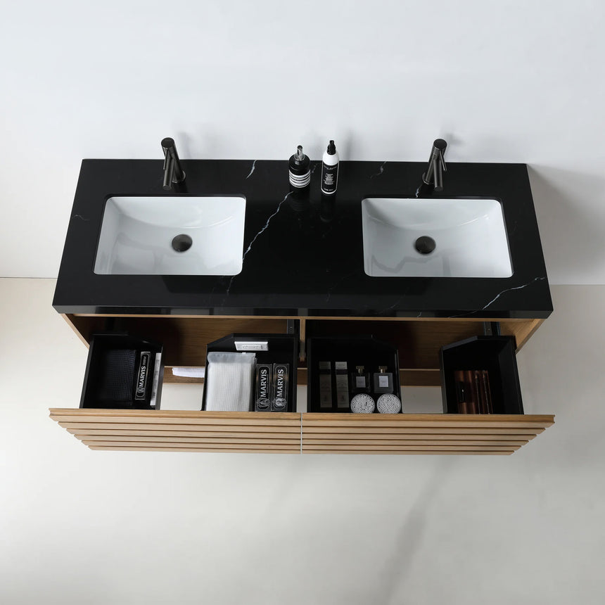 A modern floating bathroom vanity with a light oak wood finish, a white countertop, and an integrated sink, shown in a styled bathroom setting with a bathtub, shower glass, and decorative plants.
