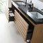 Modern floating bathroom vanity with a black countertop, integrated sinks, and light wood drawers with pull-out compartments.