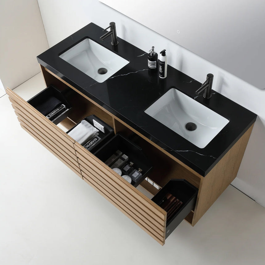 A modern floating bathroom vanity with a light oak wood finish, a white countertop, and an integrated sink, shown in a styled bathroom setting with a bathtub, shower glass, and decorative plants.
