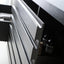 Close-up of a modern silver drawer front with a sleek, minimalist design, set within a dark wood cabinet interior.