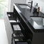 A modern black bathroom vanity with integrated sinks, open drawers, and a glossy countertop, shown in a bright bathroom setting with toiletries and bottles.