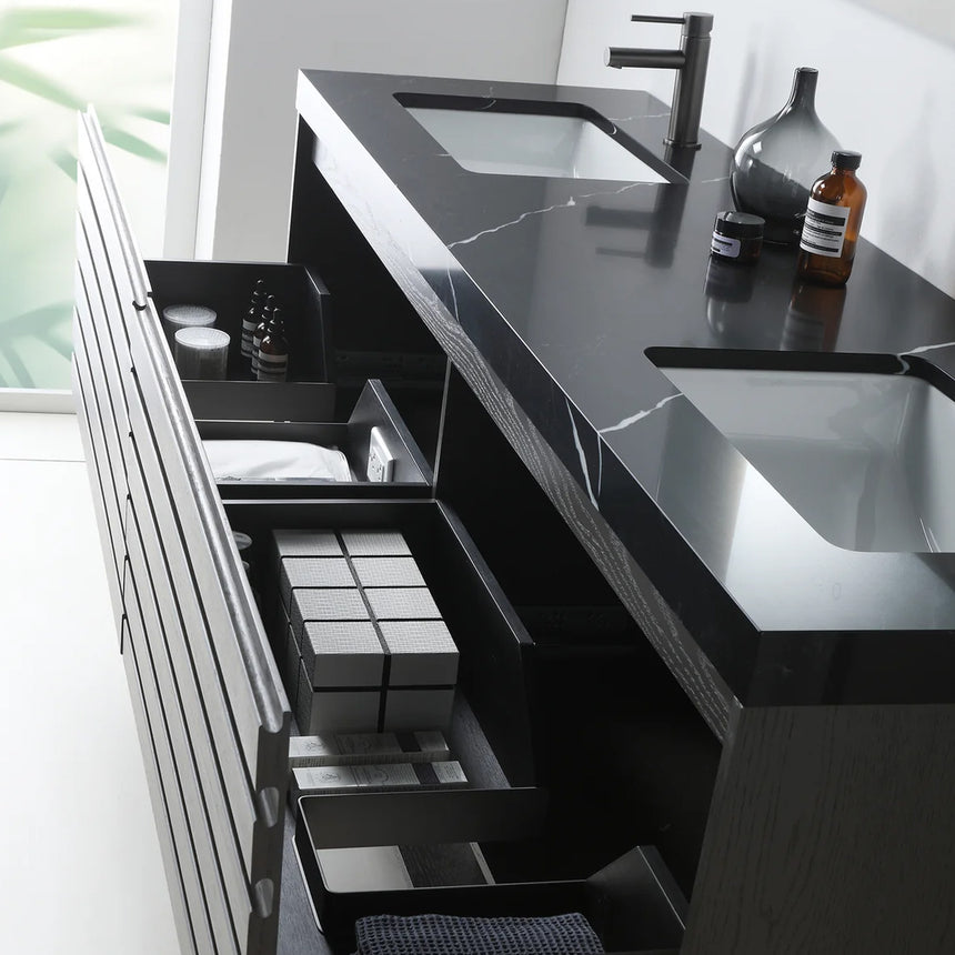 A modern floating bathroom vanity with a light oak wood finish, a white countertop, and an integrated sink, shown in a styled bathroom setting with a bathtub, shower glass, and decorative plants.