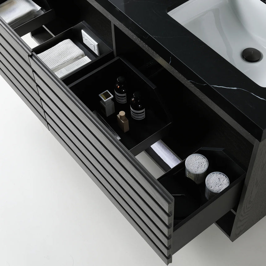 A modern floating bathroom vanity with a light oak wood finish, a white countertop, and an integrated sink, shown in a styled bathroom setting with a bathtub, shower glass, and decorative plants.
