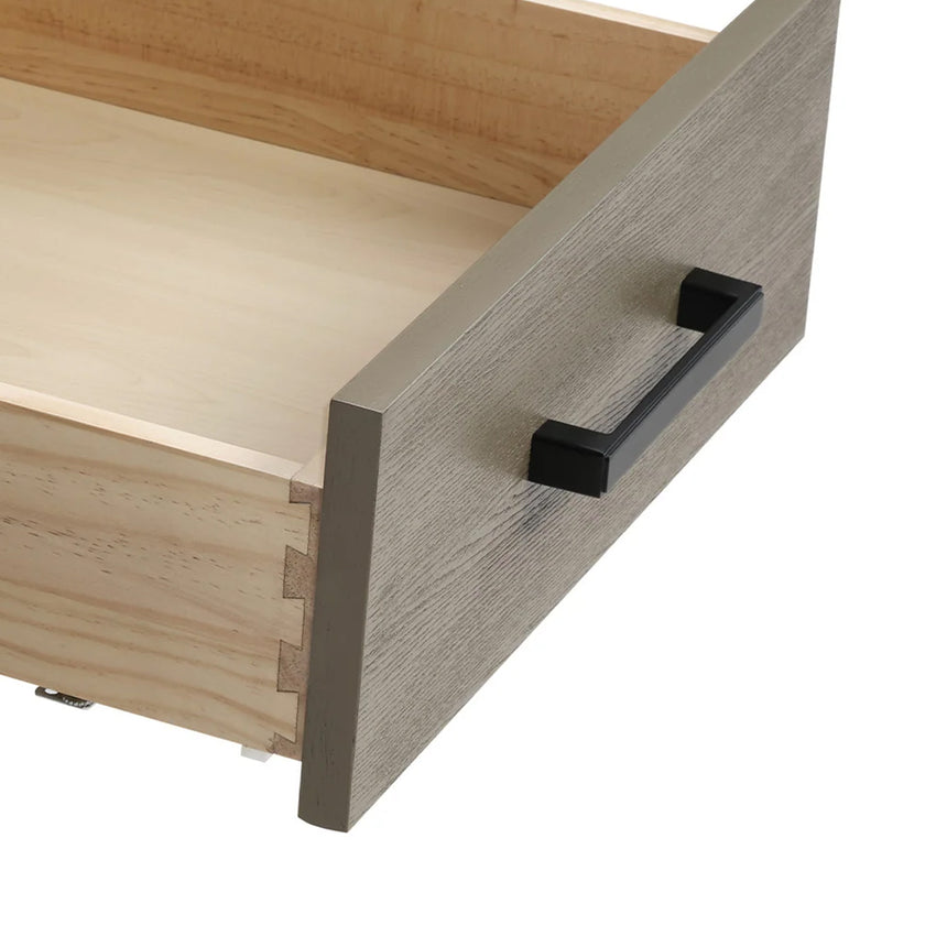 Bathroom vanity with wooden cabinets and white countertop, featuring a toilet and towel on the side.