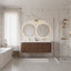 Modern bathroom with marble walls, wooden vanity, and shower area.