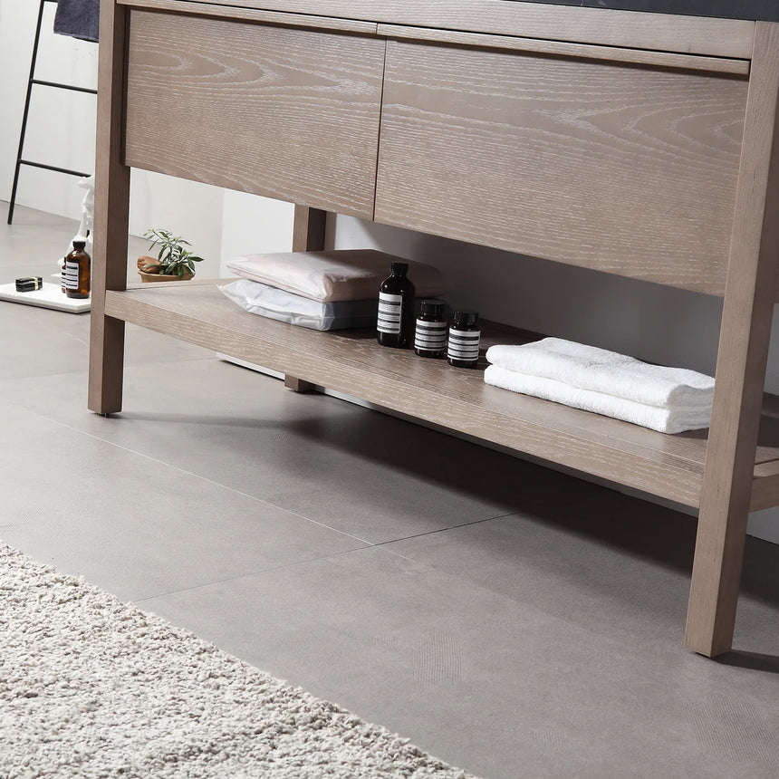 Bathroom vanity with black countertop and wooden cabinet in a bright room.