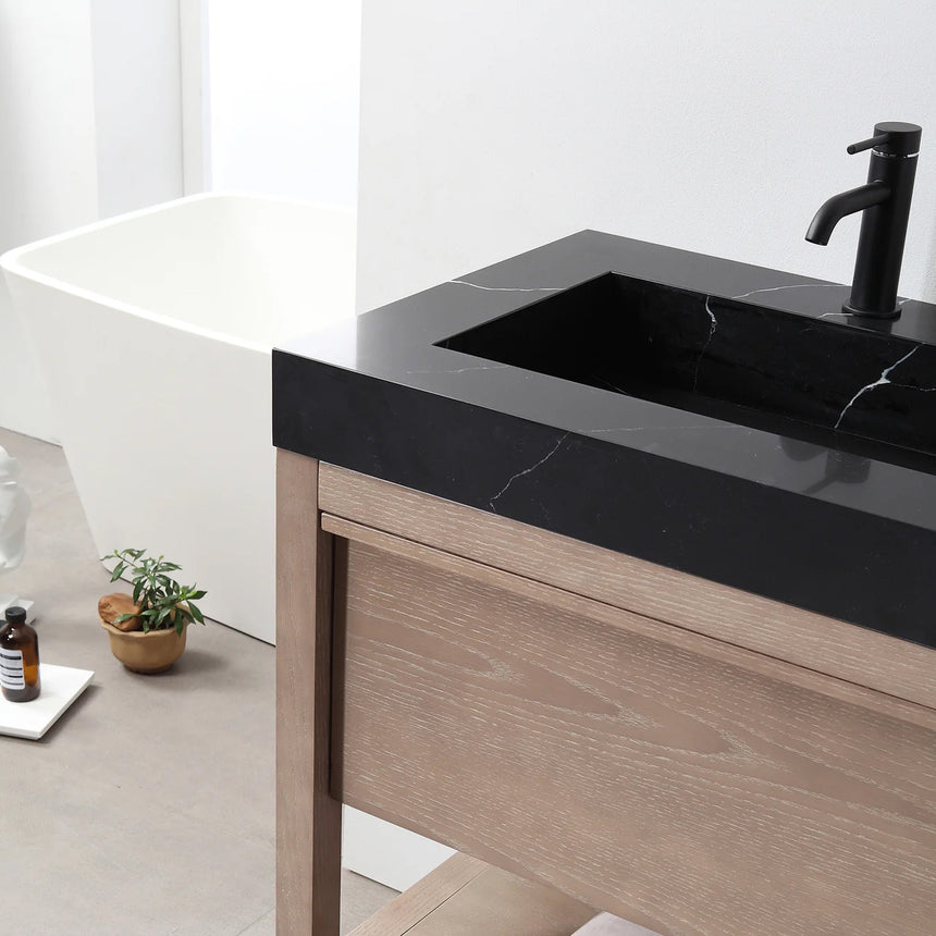 Bathroom vanity with black countertop and wooden cabinet in a bright room.