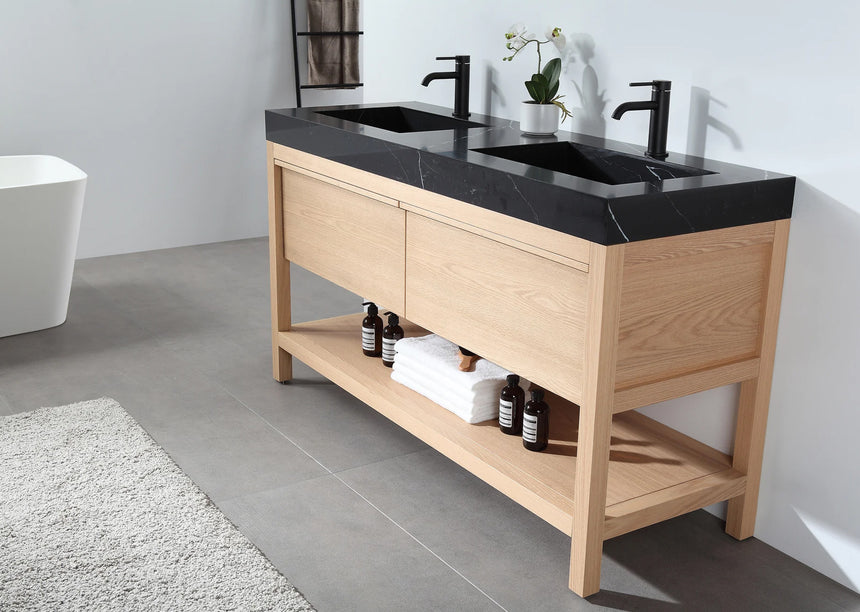 Bathroom vanity with black countertop and wooden cabinet in a bright room.