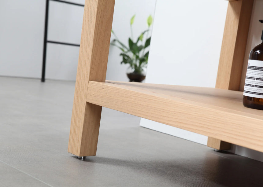 Bathroom vanity with black countertop and wooden cabinet in a bright room.