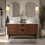 Bathroom vanity with wooden cabinet, two mirrors, and decorative items.