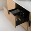 Open drawer in a wooden cabinet with a hairbrush and bottles on a white background