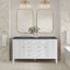 Bathroom vanity with two mirrors, lights, and a floral arrangement.