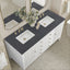 Bathroom vanity with two sinks, black countertop, and decorative flowers.