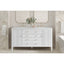 White bathroom vanity with marble countertop and decorative flowers in a bathroom setting.
