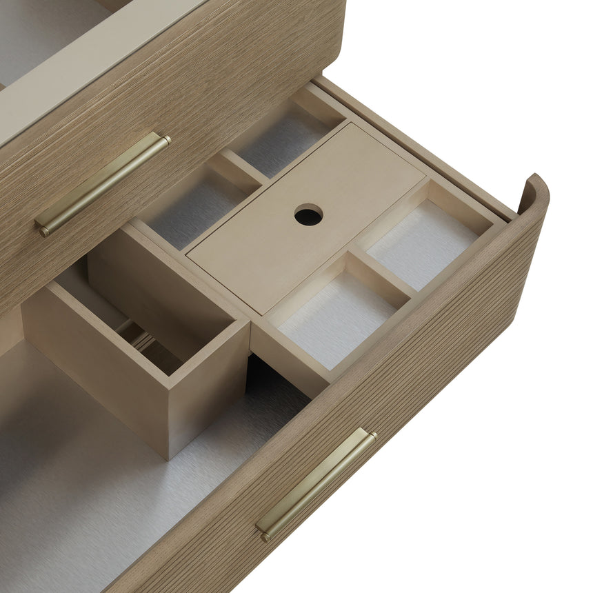 A modern bathroom vanity with a light oak wood frame, six drawers, an open lower shelf, and a white marble top with an integrated sink. The vanity is styled in a bright bathroom with a white freestanding tub, a gold faucet, and a glass shower stall in the background.