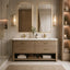 A modern double-sink bathroom vanity with a light oak wood cabinet, white marble countertop, and two matching rectangular mirrors with gold frames. The vanity is styled in a luxurious bathroom setting with warm gold hardware, wall sconces, a glass shower enclosure, and built-in shelving.