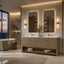 A luxury modern bathroom featuring a double-sink vanity with a light wood cabinet, two illuminated rectangular mirrors, and gold-toned hardware, set against a marble wall with a bathtub and sunset view.