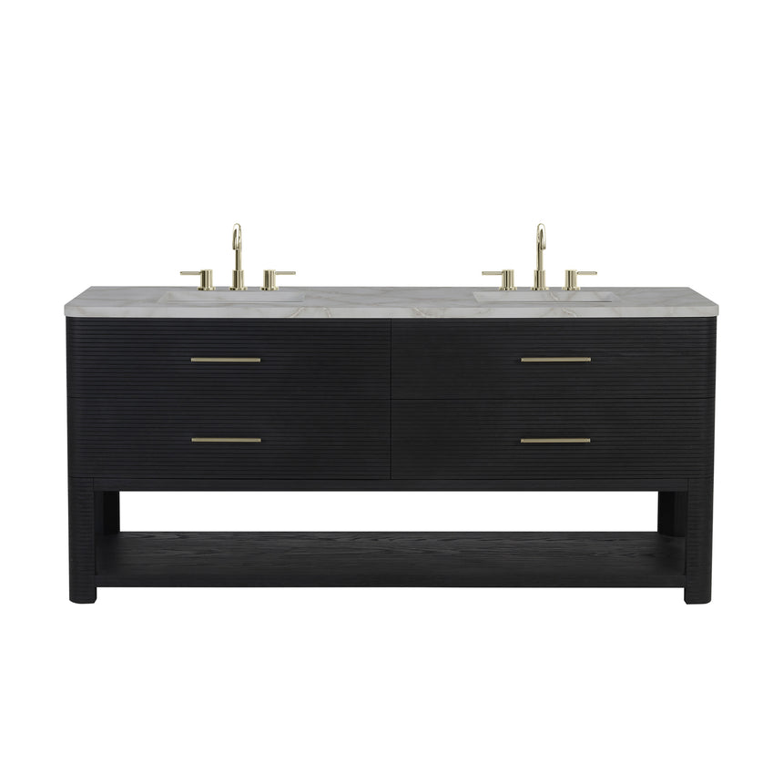 A modern bathroom vanity with a light oak wood frame, six drawers, an open lower shelf, and a white marble top with an integrated sink. The vanity is styled in a bright bathroom with a white freestanding tub, a gold faucet, and a glass shower stall in the background.