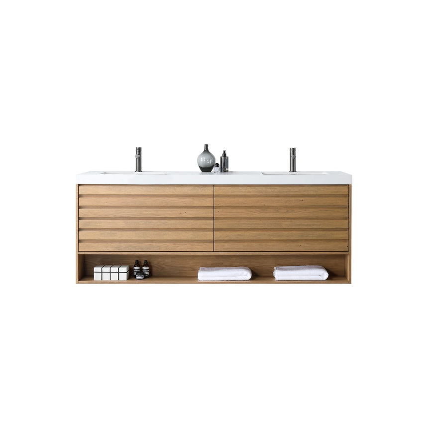 A modern floating bathroom vanity with a light oak wood finish, a white countertop, and an integrated sink, shown in a styled bathroom setting with a bathtub, shower glass, and decorative plants.