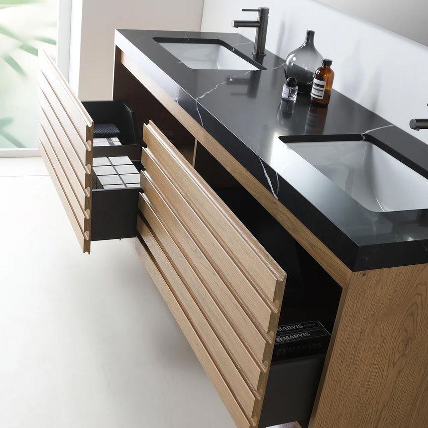 A modern floating bathroom vanity with a light oak wood finish, a white countertop, and an integrated sink, shown in a styled bathroom setting with a bathtub, shower glass, and decorative plants.