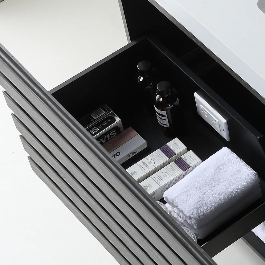 A modern floating bathroom vanity with a light oak wood finish, a white countertop, and an integrated sink, shown in a styled bathroom setting with a bathtub, shower glass, and decorative plants.