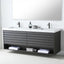 A modern double-sink bathroom vanity with a dark gray floating cabinet, white countertop, matte black faucets, and open lower shelf storage with folded towels and toiletries, shown against a white wall and mirror.