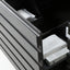 Close-up of a dark gray drawer with a slatted front, partially open to reveal white tissue paper and a boxed item inside.