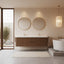 Modern bathroom with wooden vanity, round mirrors, and a freestanding bathtub.
