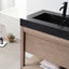 Bathroom vanity with black countertop and wooden cabinet