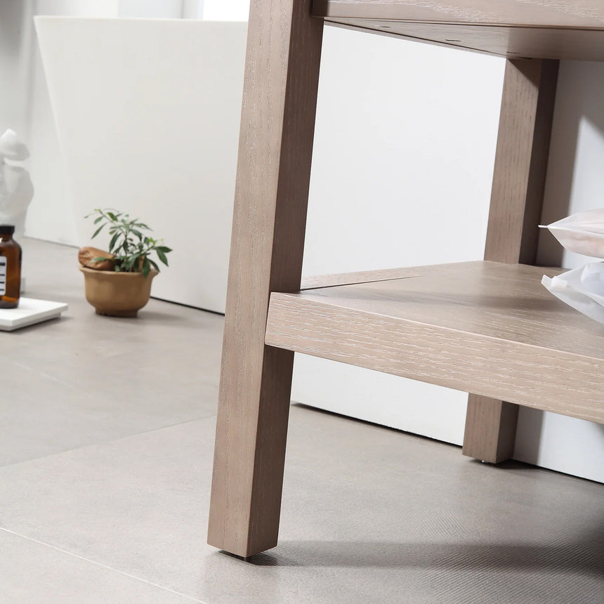 Bathroom vanity with black countertop and wooden cabinet in a bright room.