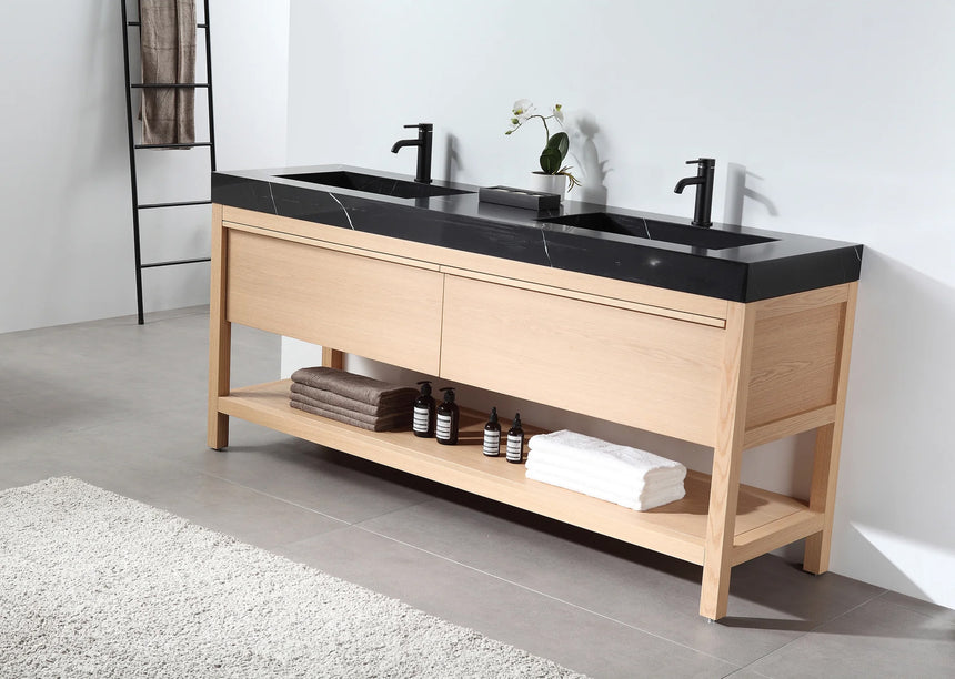 Bathroom vanity with black countertop and wooden cabinet in a bright room.