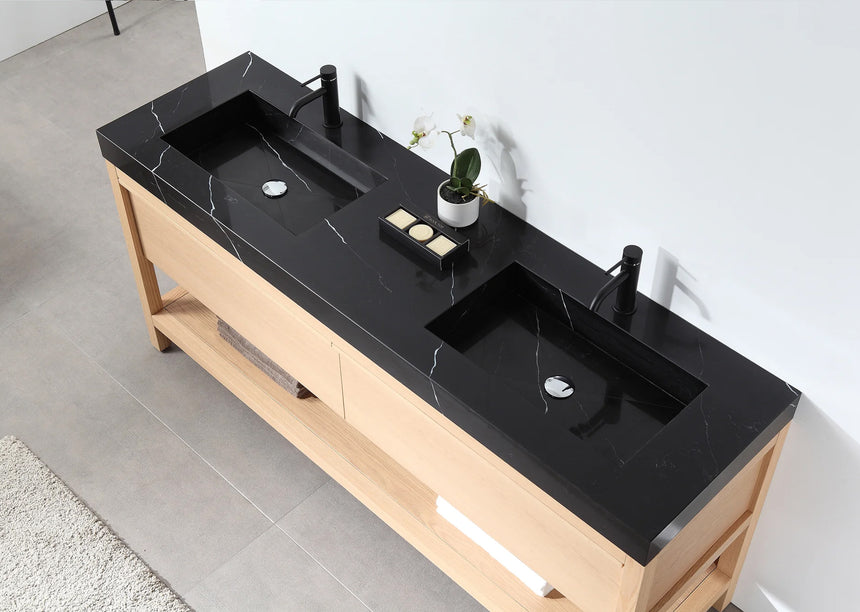 Bathroom vanity with black countertop and wooden cabinet in a bright room.