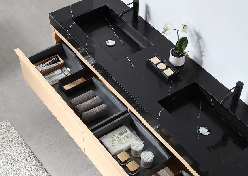 Bathroom vanity with black countertop and wooden cabinet in a bright room.