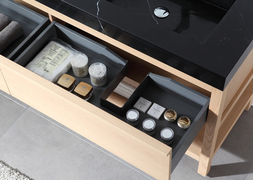 Bathroom vanity with black countertop and wooden cabinet in a bright room.