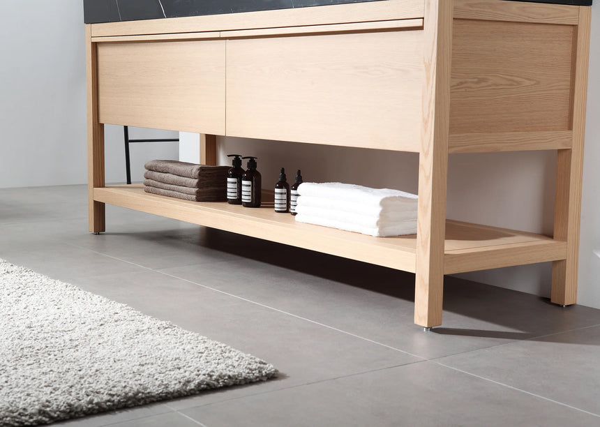 Bathroom vanity with black countertop and wooden cabinet in a bright room.