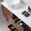 Bathroom vanity with open drawer, white sink, and toiletries.