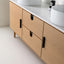 Wooden bathroom vanity with white countertop and round sinks.