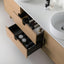 Bathroom vanity with open drawer containing Marvis products, white sink, and toiletries.